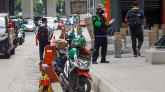 Ojek online mengantar barang di Jalan Rasuna Said, Jakarta Selatan, Selasa (6/12/2022). [Suara.com/Alfian Winanto]