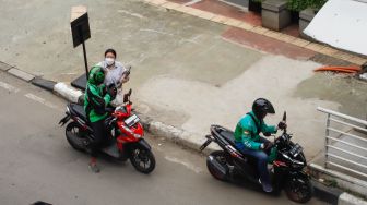 Ojek online menjemput penumpang di Jalan Rasuna Said, Jakarta Selatan, Selasa (6/12/2022). [Suara.com/Alfian Winanto]