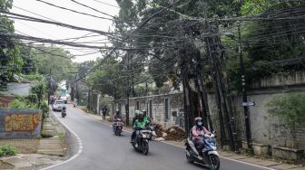 Instalasi kabel yang semrawut terlihat di Jalan Kemang Utara, Mampang Prapatan, Jakarta Selatan, Rabu (7/12/2022). [Suara.com/Alfian Winanto]