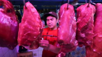 Pedagang memilih daging sapi untuk pembei di Pasar Santa, Jakarta Selatan, Jumat (9/12/2022). [Suara.com/Alfian Winanto]