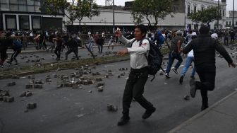 Pendukung mantan Presiden Peru Pedro Castillo bentrok dengan polisi untuk mencapai Prefektur Lima tempat Castillo ditahan, di Lima, Peru, Rabu (7/12/2022). [ERNESTO BENAVIDES / AFP]
