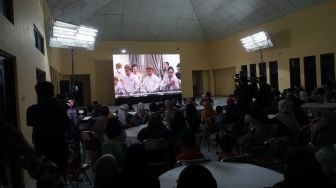 Warga menyaksikan prosesi adat malam midodareni jelang pernikahan Kaesang Pangarep dengan Erina Gudono melalui layar di gedung serbaguna Purwosari, Sinduadi, Mlati, Sleman, D.I Yogyakarta, Jumat (9/12/2022). [ANTARA FOTO/Andreas Fitri Atmoko/nz]