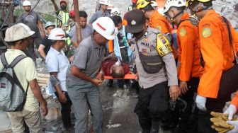 Sejumlah pekerja dan anggota polisi menggotong relawan yang mencari korban di bekas ledakan pada lokasi tambang batu bara di Kecamatan Talawi, Kabupaten Sawahlunto, Sumatera Barat, Jumat (9/12/2022). [ANTARA FOTO/Muhammad Arif Pribadi/nz]