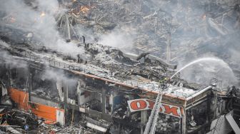 Petugas pemadam kebakaran berusaha memadamkan api besar yang membakar pusat perbelanjaan dan hiburan Mega Khimki di pinggiran utara Moskow, Rusia, Jumat (9/12/2022). [Alexander NEMENOV / AFP]