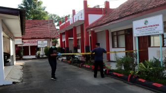 Petugas memasang garis polisi saat olah TKP di salah satu ruangan Rumah Dinas (Rumdin) Wali Kota Blitar, Jawa Timur, Senin (12/12/2022).  ANTARA FOTO/Humas Polres Blitar Kota