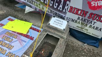 Warga Sumbawa Barat, NTB, menggelar aksi mogok makan dan mendirikan tenda di halaman kantor Komnas HAM. Mereka membawa empat batu nisa bertuliskan nama korban. [Suara.com/Yaumal] 