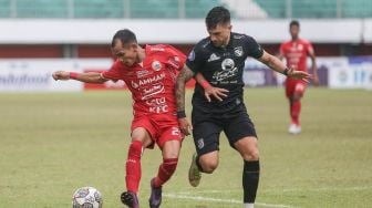 Pesepak bola Persija Jakarta Riko Simanjuntak (kiri) berebut bola dengan pesepak bola Persebaya Surabaya Higor Vidal (kanan) pada pertandingan Liga 1 di Stadion Maguwoharjo, Sleman, DI Yogyakarta, Jumat (16/12/2022).  ANTARA FOTO/Hendra Nurdiyansyah