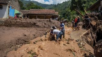 Warga membersihkan puing akibat banjir bandang di Sawahdadap, Cimanggung, Kabupaten Sumedang, Jawa Barat, Minggu (18/12/2022). [ANTARA FOTO/Ahmad Fauzan].