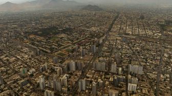 Pemandangan kota yang diselimuti asap dari kebakaran hutan yang melanda daerah sekitarnya di Santiago, Chili, Jumat (16/12/2022). [JAVIER TORRES / AFP]