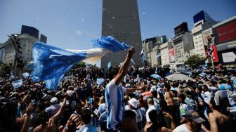 Fans Argentina berkumpul di Tugu Obelisk untuk merayakan kemenangan Piala Dunia Qatar 2022 melawan Prancis di Buenos Aires, Argentina, Minggu (18/12/2022). [Emiliano Lasalvia / AFP]