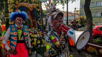 Para badut memainkan musik saat mengikuti prosesi penghormatan kepada santo pelindung Meksiko, Our Lady of Guadalupe, di Mexico City, Meksiko, Senin (19/12/2022). [CLAUDIO CRUZ/AFP]