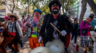 Para badut memainkan musik saat mengikuti prosesi penghormatan kepada santo pelindung Meksiko, Our Lady of Guadalupe, di Mexico City, Meksiko, Senin (19/12/2022). [CLAUDIO CRUZ/AFP]