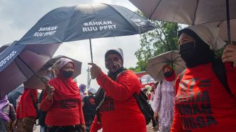 Sejumlah Ibu Pekerja Rumah Tangga (PRT) melakukan aksi Rabuan PRT: Payung Duka Seribu Ibu-Ibu PRT Indonesia di Taman Aspirasi Monas, Jakarta Pusat, Rabu (21/12/2022). [Suara.com/Alfian Winanto]