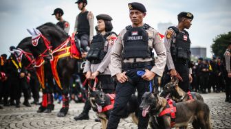 Polisi membawa anjing pelacak saat mengikuti apel Gelar Pasukan Operasi Lilin 2022 di Kawasan Monas, Jakarta, Kamis (22/12/2022). [ANTARA FOTO/Rivan Awal Lingga].