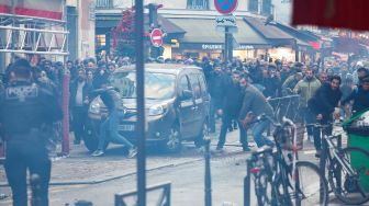 Para pengunjuk rasa bentrok dengan petugas polisi anti huru hara Prancis menyusul insiden penembakan kepada komunitas Suku Kurdi di Paris, Prancis, Jumat (23/12/2022). [Thomas SAMSON / AFP]