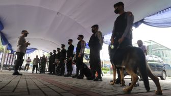 Personel kepolisian melakukan apel sebelum  melakukan sterilisasi dan pengamanan di Gereja Katedral, Jakarta Pusat, Sabtu (24/12/2022). [Suara.com/Alfian Winanto]