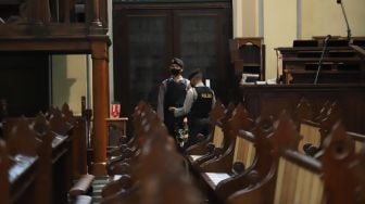 Personel kepolisian saat melakukan sterilisasi dan pengamanan di Gereja Katedral, Jakarta Pusat, Sabtu (24/12/2022). [Suara.com/Alfian Winanto]