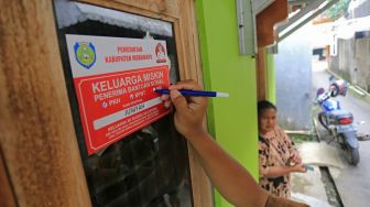 Petugas menempelkan stiker Keluarga Miskin di salah satu rumah Keluarga Penerima Manfaat (KPM) bantuan sosial di Indramayu, Jawa Barat, Senin (26/12/2022). [ANTARA FOTO/Dedhez Anggara].