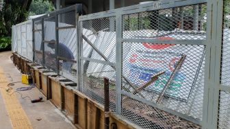 Pekerja menyelesaikan proyek pemasangan pagar di Tebet Eco Park, Tebet, Jakarta Selatan, Jumat (30/12/2022). [Suara.com/Alfian Winanto]