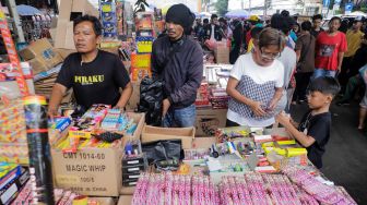 Pedagang kembang api melayani pembeli di Pasar Asemka, Jakarta Barat, Jumat (30/12/2022). [Suara.com/Alfian Winanto]