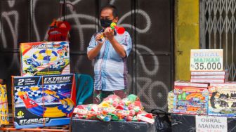 Pedagang Terompet melayani pembeli di Pasar Asemka, Jakarta Barat, Jumat (30/12/2022). [Suara.com/Alfian Winanto]