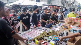 Pedagang kembang api melayani pembeli di Pasar Asemka, Jakarta Barat, Jumat (30/12/2022). [Suara.com/Alfian Winanto]