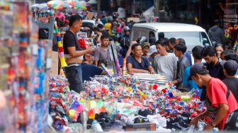 Pedagang kembang api melayani pembeli di Pasar Asemka, Jakarta Barat, Jumat (30/12/2022). [Suara.com/Alfian Winanto]