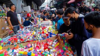 Pedagang Terompet melayani pembeli di Pasar Asemka, Jakarta Barat, Jumat (30/12/2022). [Suara.com/Alfian Winanto]