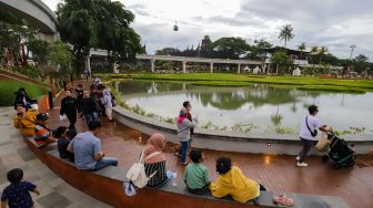 Pengunjung beraktivitas saat berwisata di Taman Mini Indonesia Indah (TMII), Jakarta Timur, Sabtu (31/12/2022). [Suara.com/Alfian Winanto]