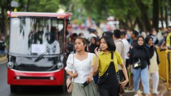 Pengunjung beraktivitas saat berwisata di Taman Mini Indonesia Indah (TMII), Jakarta Timur, Sabtu (31/12/2022). [Suara.com/Alfian Winanto]