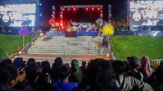 Pengunjung menyaksikan grup musik Mocca saat perayaan tahun baru 2023 di Taman Mini Indonesia Indah (TMII), Jakarta Timur, Sabtu (31/12/2022). [Suara.com/Alfian Winanto,]