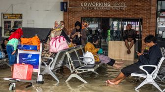 Sejumlah penumpang menanti keberangkatan kereta api yang mengalami keterlambatan akibat banjir yang merendam jalur kereta api maupun stasiun di Stasiun Tawang, Semarang, Jawa Tengah, Sabtu (31/12/2022). [ANTARA FOTO/Aji Styawan]