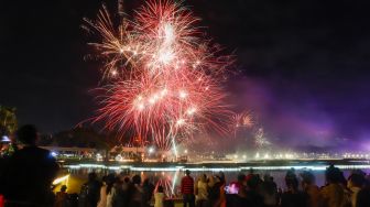 Warga menyaksikan pesta kembang api saat perayaan malam Tahun Baru 2023 di Danau Archipelago, Taman Mini Indonesia Indah (TMII), Jakarta Timur, Minggu (1/1/2023). [Suara.com/Alfian Winanto]