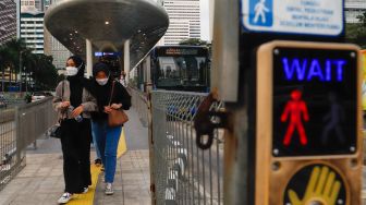 Pekerja melintas saat jam pulang kerja di Kawasan Sudirman - Thamrin, Jakarta Pusat, Senin (2/1/2023). [Suara.com/Alfian Winanto] 