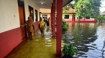 Guru mengecek kondisi sekolah yang terdampak banjir di SDN 3 Jati, Kudus, Jawa Tengah, Senin (2/1/2023). [ANTARA FOTO/Yusuf Nugroho].