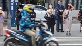 Pekerja melintas saat jam pulang kerja di Kawasan Sudirman - Thamrin, Jakarta Pusat, Senin (2/1/2023). [Suara.com/Alfian Winanto] 