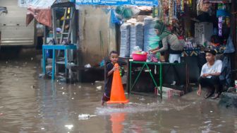 Warga beraktivitas saat banjir di Jalan Kemang Utara IX, Jakarta Selatan, Rabu (4/1/2023). [Suara.com/Alfian Wina Winanto]