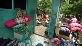 Petugas dan warga membersihkan puing-puing rumah yang hancur diterjang banjir bandang di Desa Kemiriamba, Jatibarang, Brebes, Jawa Tengah, Kamis (5/1/2023). [ANTARA FOTO/Oky Lukmansyah]