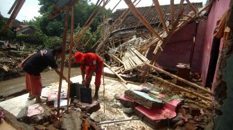 Petugas dan warga membersihkan puing-puing rumah yang hancur diterjang banjir bandang di Desa Kemiriamba, Jatibarang, Brebes, Jawa Tengah, Kamis (5/1/2023). [ANTARA FOTO/Oky Lukmansyah]