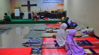 Pengungsi korban banjir melakukan shalat di ruang aula Gereja Kristen Muria Indonesia (GKMI) Tanjung Karang, Kudus, Jawa Tengah, Rabu (4/1/2023). [ANTARA FOTO/Yusuf Nugroho]