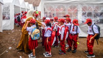 Sejumlah anak baris berbaris sebelum memasuki tenda sekolah darurat di SDN Citamiang, Sarongge, Kabupaten Cianjur, Jawa Barat, Senin (9/1/2023). [ANTARA FOTO/Raisan Al Farisi/hp]