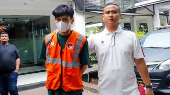 Aktor Revaldo Fifaldi dibawa petugas untuk dihadirkan saat rilis kasus narkoba yang menjeratnya di Polda Metro Jaya, Jakarta, Jumat (13/1/2023). [Suara.com/Alfian Winanto]