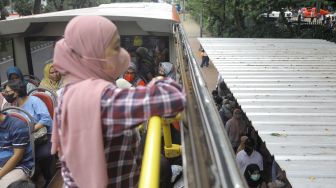 Warga saat menaiki bus tingkat Transjakarta dengan atap terbuka di Jakarta, Sabtu (14/1/2023). [Suara.com/Alfian Winanto]