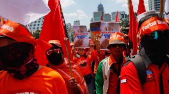 Massa aksi dari Partai Buruh dan beberapa serikat buruh lainnya menggelar aksi di Kawasan Patung Kuda Arjuna, Jakarta Pusat, Sabtu (14/1/2023). [Suara.com/Alfian Winanto]