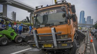 Petugas melakukan evakuasi truk bermuatan batu bara yang mengalami kecelakaan beruntun di Jalan Tol Dalam Kota, Cawang-Grogol KM 5400, di Jakarta, Rabu (18/1/2023). [ANTARA FOTO/Galih Pradipta].