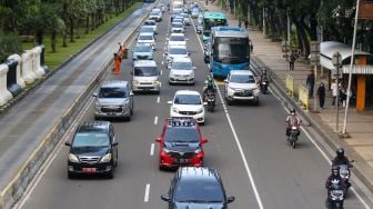 Sejumlah kendaraan bermotor melintas di Jalan Medan Merdeka Barat, Jakarta Pusat, Kamis (19/1/2023). [Suara.com/Alfian Winanto]