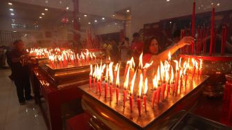 Warga keturunan Tionghoa meletakkan dupa dan membakar lilin saat melaksanakan ibadah pada malam tahun baru imlek di Vihara Dharma Bakti, Banda Aceh, Aceh Minggu (22/1/2023). [ANTARA FOTO / Irwansyah Putra/aww]