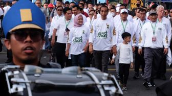 Presiden Joko Widodo (tengah) didampingi Ibu Negara Iriana Joko Widodo (kedua kiri) dan cucunya Jan Ethes (kedua kanan) serta Ketua Umum PBNU Yahya Cholil Staquf (kanan) dan sejumlah tokoh nasional mengikuti jalan sehat dalam rangka menuju satu abad Nahdlatul Ulama (NU) di Solo, Jawa Tengah, Minggu (22/1/2023). [ANTARAFOTO/Maulana Surya/aww]