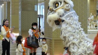 Wisatawan mancanegara asal China disambut kesenian Barongsai setibanya di Terminal Internasional Bandara Internasional I Gusti Ngurah Rai, Badung, Bali, Minggu (22/1/2023). [ANTARA FOTO/Fikri Yusuf/aww]