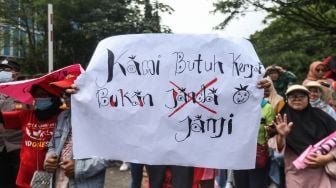 Sejumlah warga membawa poster dalam aksi unjuk rasa di depan Gudang Lazada, Jatijajar, Depok, Jawa Barat, Senin (23/1/2023).  [ANTARA FOTO/Asprilla Dwi Adha]